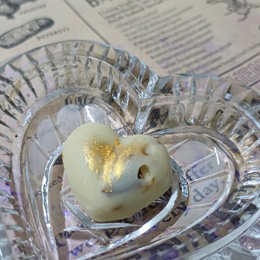 Bombones con chocolate blanco en forma de corazon con frutos secos ,decoradas con pan de oro
