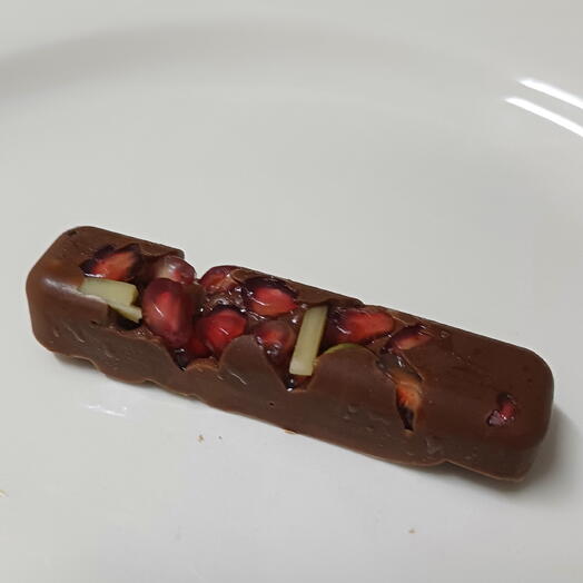 Bombon de chocolate con frutos secos y semillas de granada decorado con pan de oro comestible
