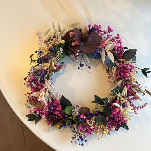 Декоративний вінок із стабілізованих квітів у відтінках фуксії та фіолетового