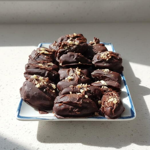 Datiles rellenos con nueces y crema de cacahuetes banados en chocolate negro.(2€ por datil)