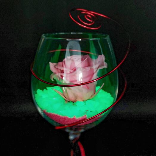 Pink preserved rose in a crystal cup, the stone that adorns the rose glows in the dark