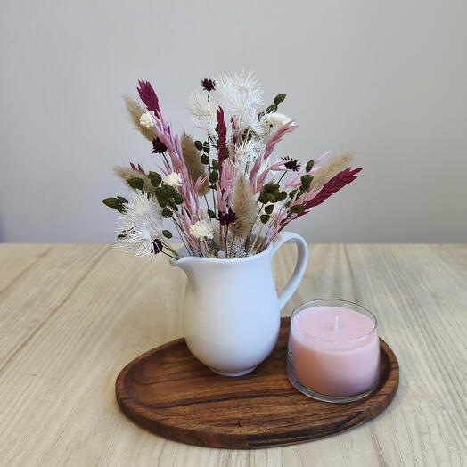 Centro de flores secas con vela rosa en bandeja