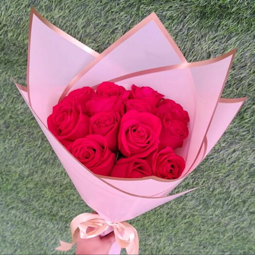 Ramo de rosas rojas con papel rosa