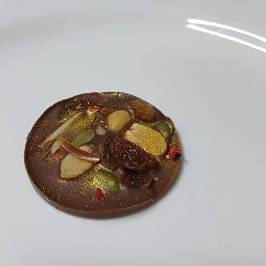 Medallon de chocolate con leche,frutos secos,pan de oro comestible