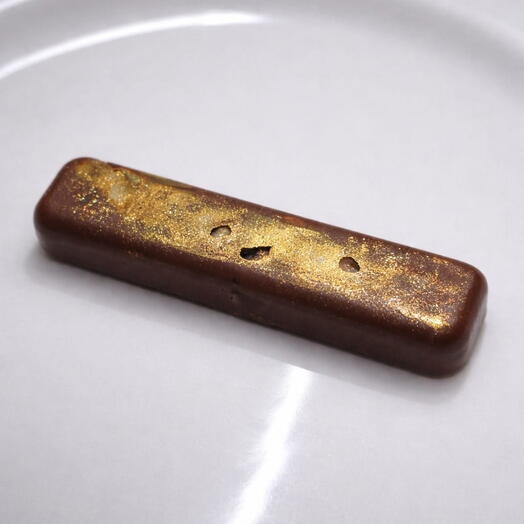 Bombon de chocolate con leche con frutos secos decorado con pan de oro comestible