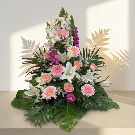 Centro floral elegante en tonos suaves con orquideas, rosas y liliums